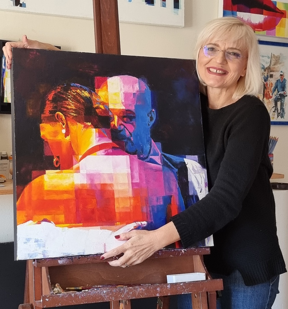 assunta-cassa-with-the-embrace-painting Artist Assunta Cassa holding her painting “The Embrace” in her studio.