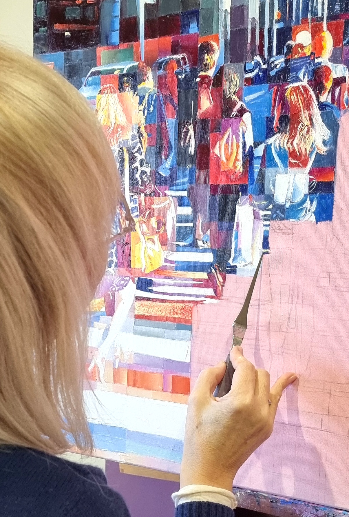 Artist in her studio meticulously working on a painting, demonstrating the ongoing process of artistic growth.