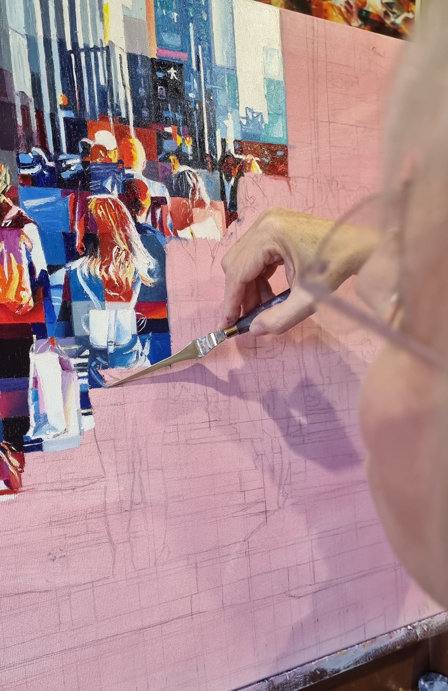 Close-up of the Italian artist Assunta Cassa painting a detailed cityscape, showcasing the reflection and inspiration in artistic creation.