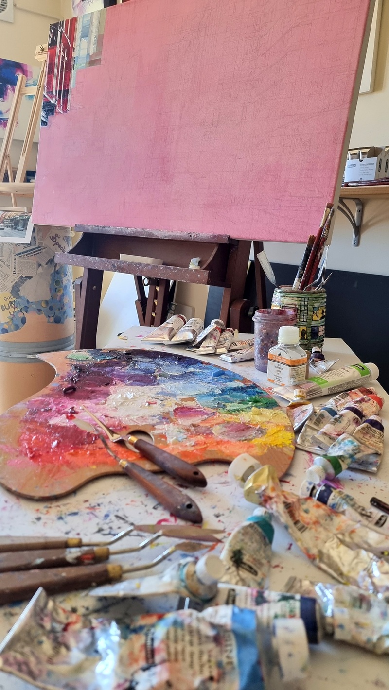 Studio d'arte di Assunta Cassa Studio dell’artista con tubetti di colore, spatole e una tela quadrettata pronta per essere dipinta.