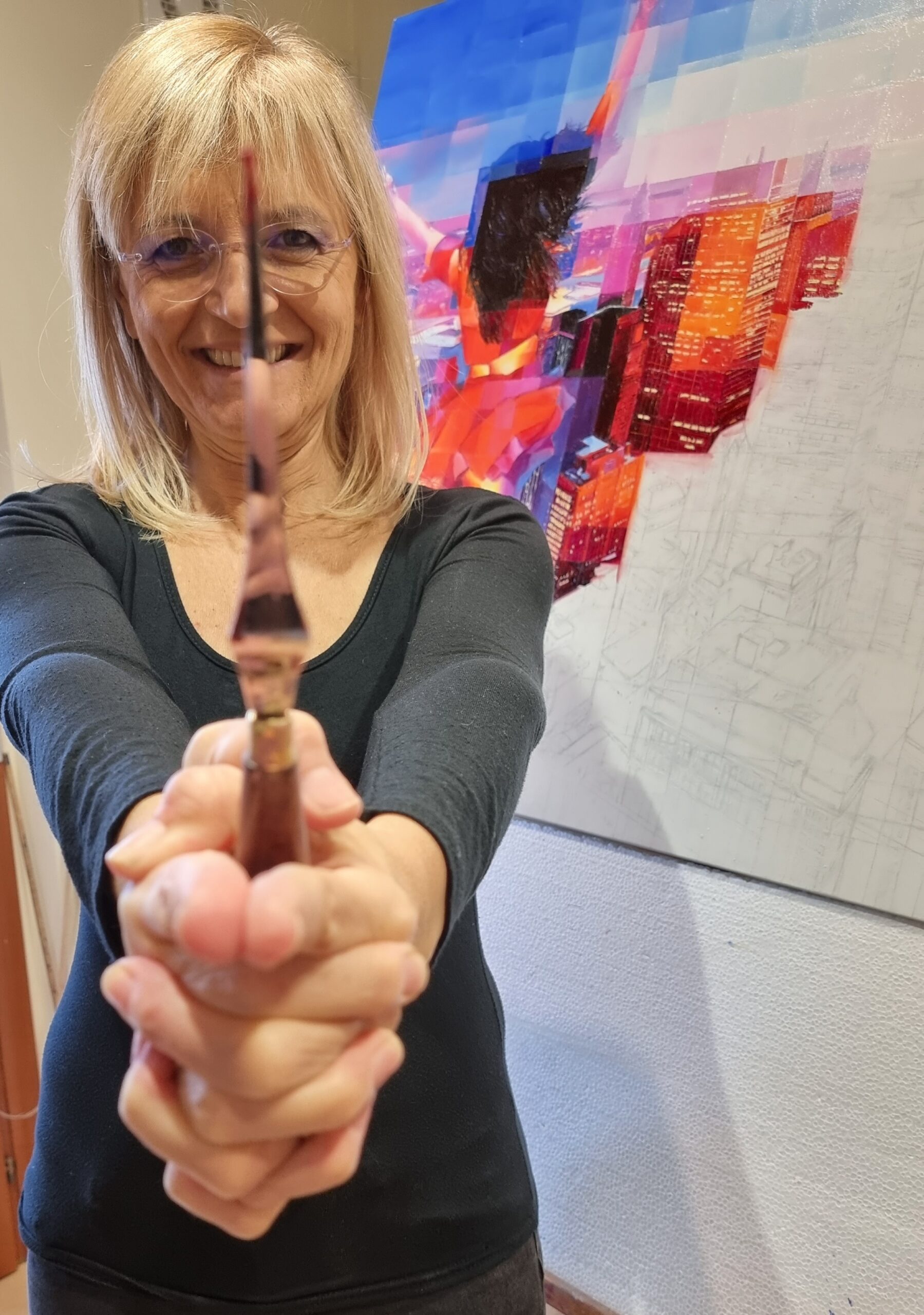Energia e gioco con la spatola Primo piano dell’artista con spatola davanti a un dipinto urbano colorato.