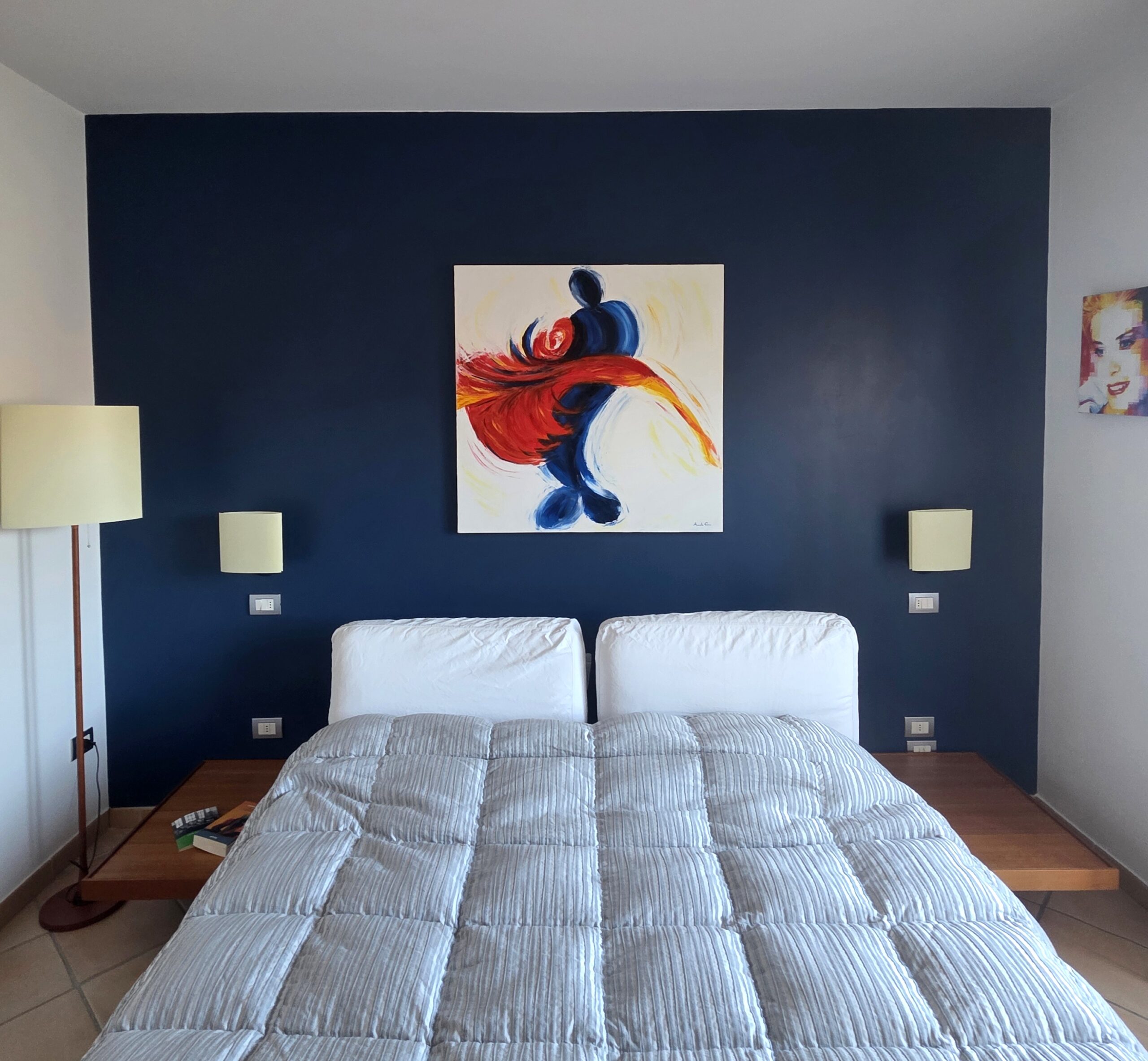 die kraft der farben — tiefblaue Schlafzimmerwand mit Gemälde über dem Bett