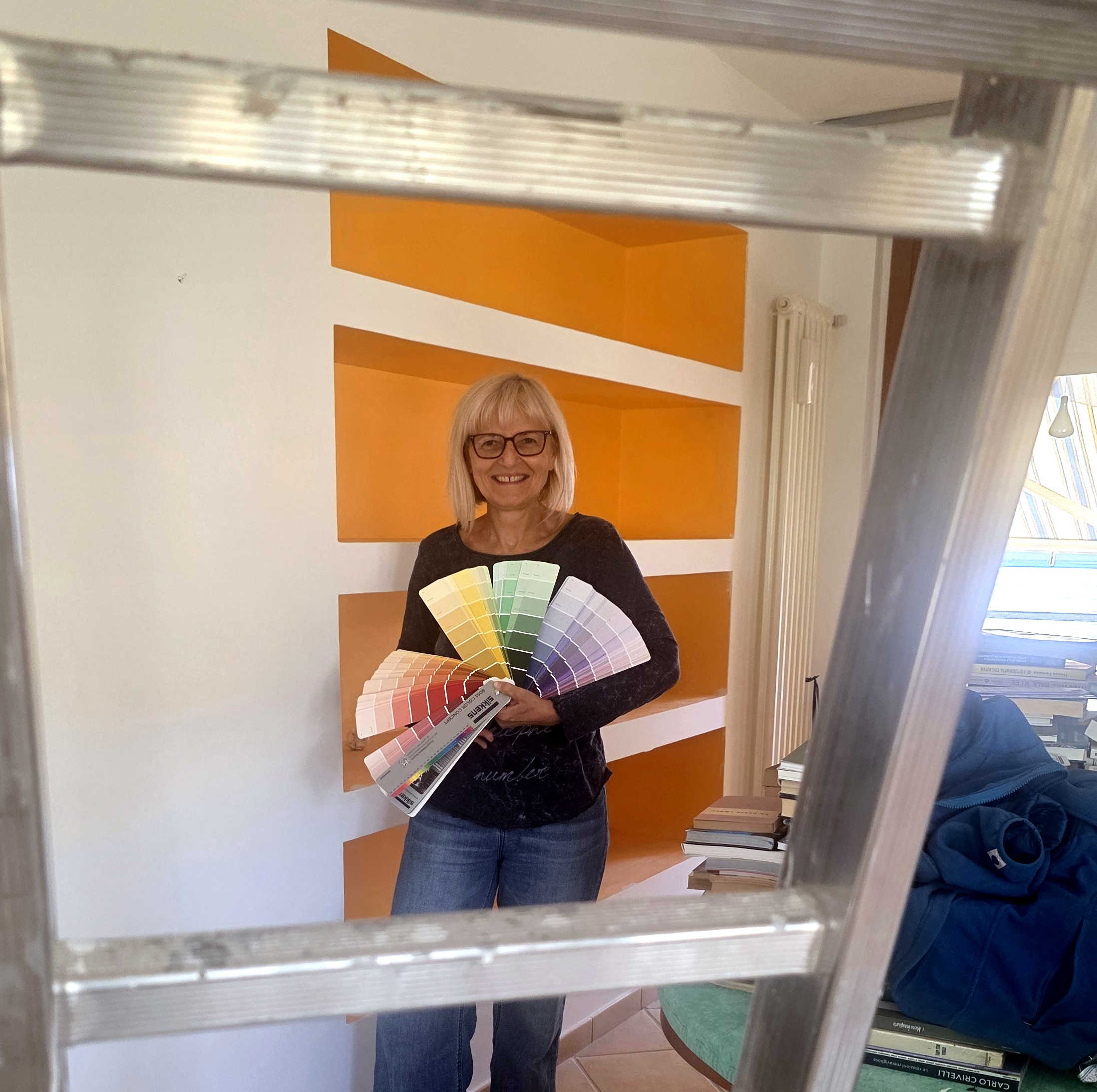 Il potere dei colori — scegliere la palette giusta il potere dei colori — artista con mazzetta di colori davanti a parete arancio