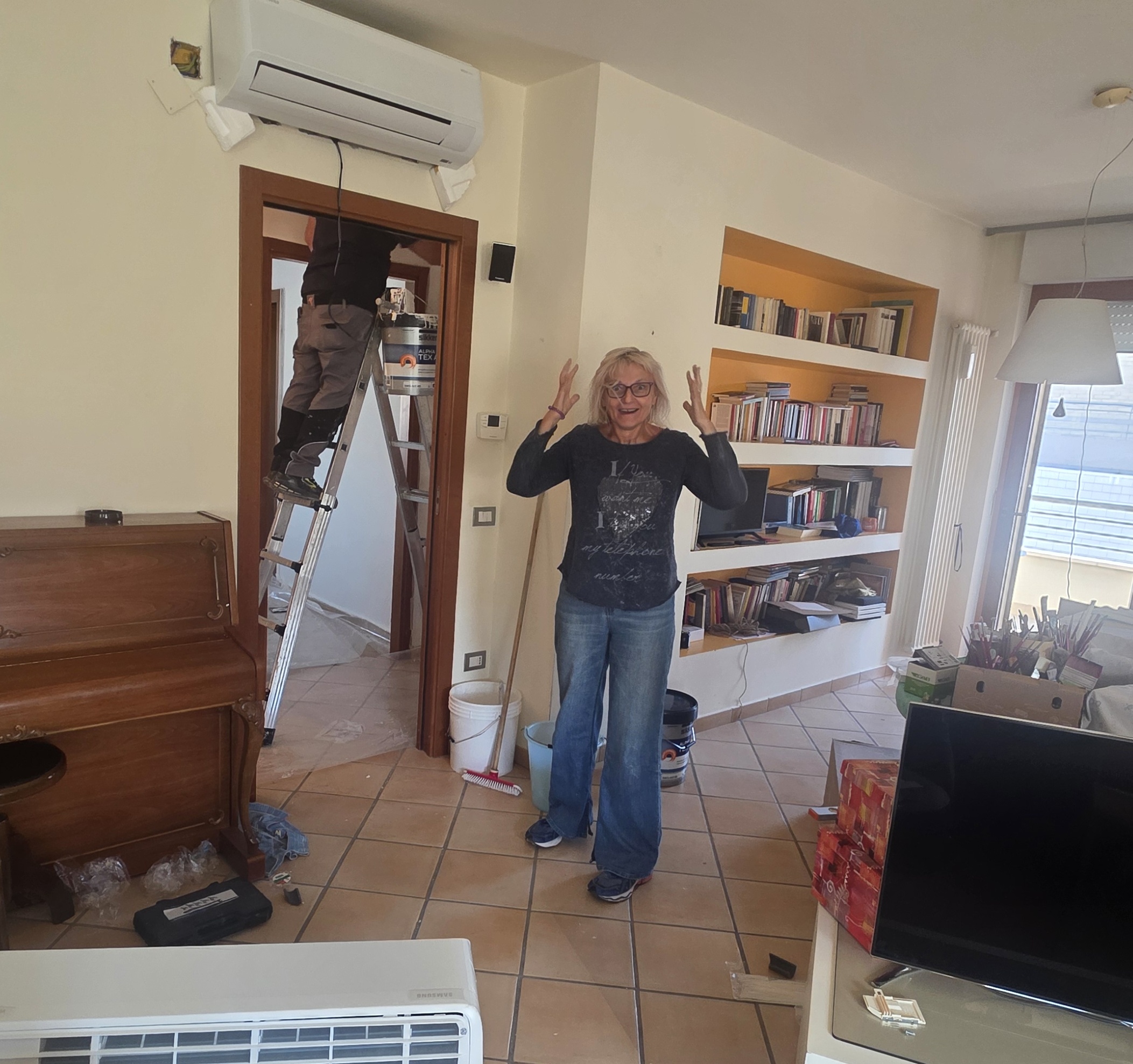 Rinnovare con il sorriso — inizio dei lavori a casa il potere dei colori — artista sorridente accanto all’imbianchino durante i lavori