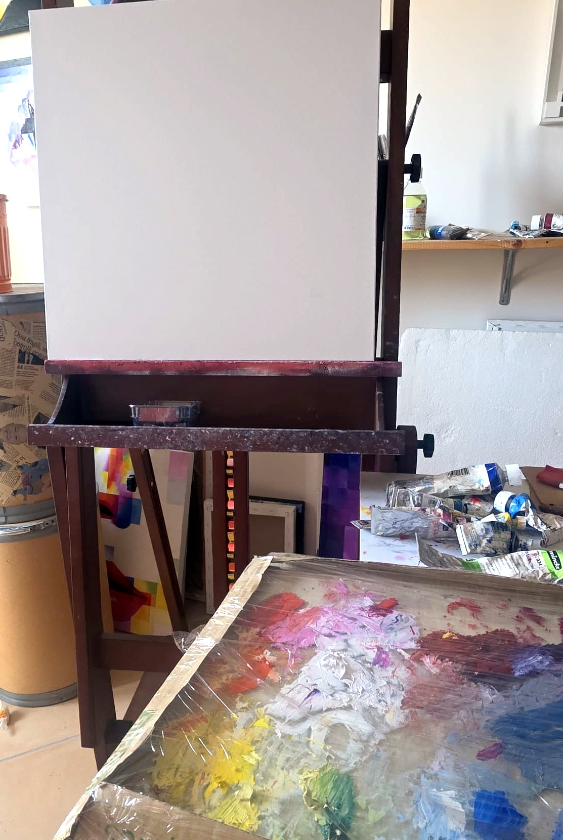 Assunta Cassa's studio: easel with blank canvas and oil color palette in the foreground