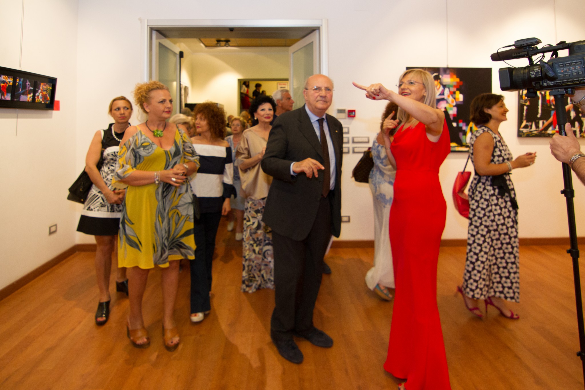 Assunta Cassa in abito rosso durante una visita alla mostra personale Oltre l'orizzonte al Palazzetto dell'Arte di Foggia nel 2017.